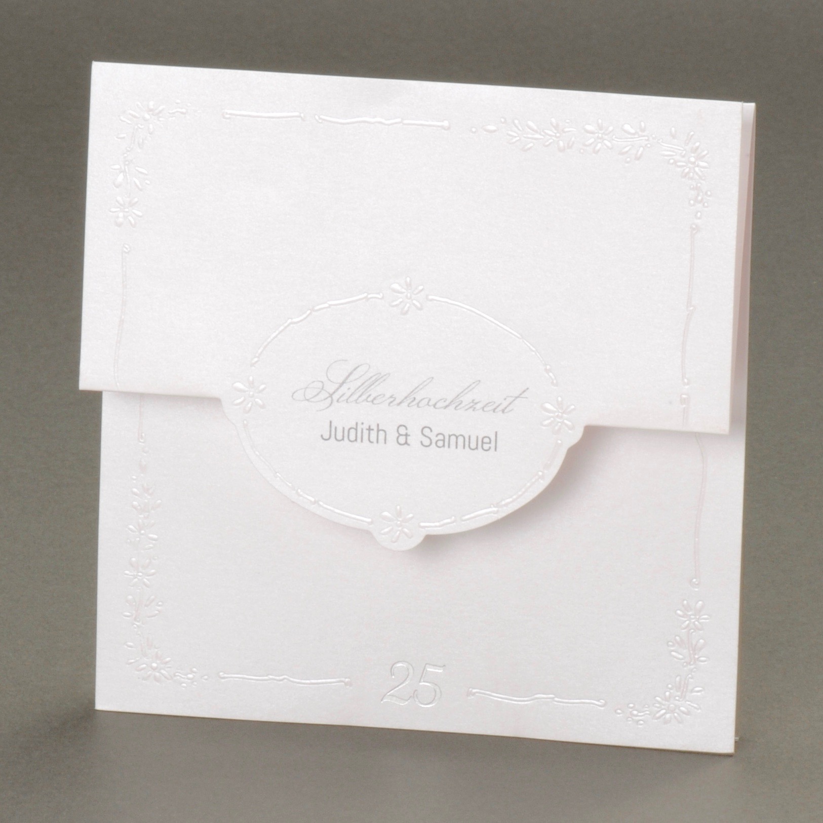 Dreiteilige perlmuttfarbene Karte mit geprägten Blumen und Kuvert weiß.