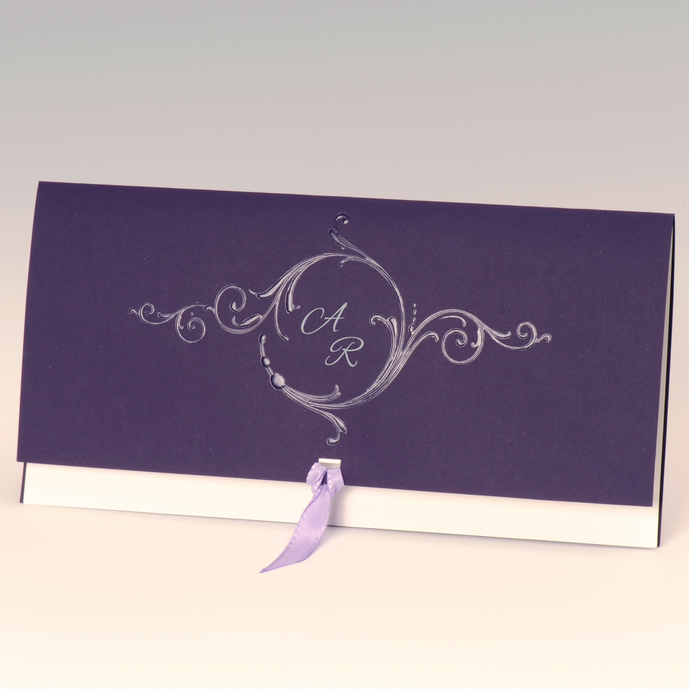 Lilafarbene Außenkarte mit weißem Einleger, Satinband in flieder und Kuvert in weiß<br>
<b> Folienprägung (Initialen) bereits im Preis inbegriffen! </b>