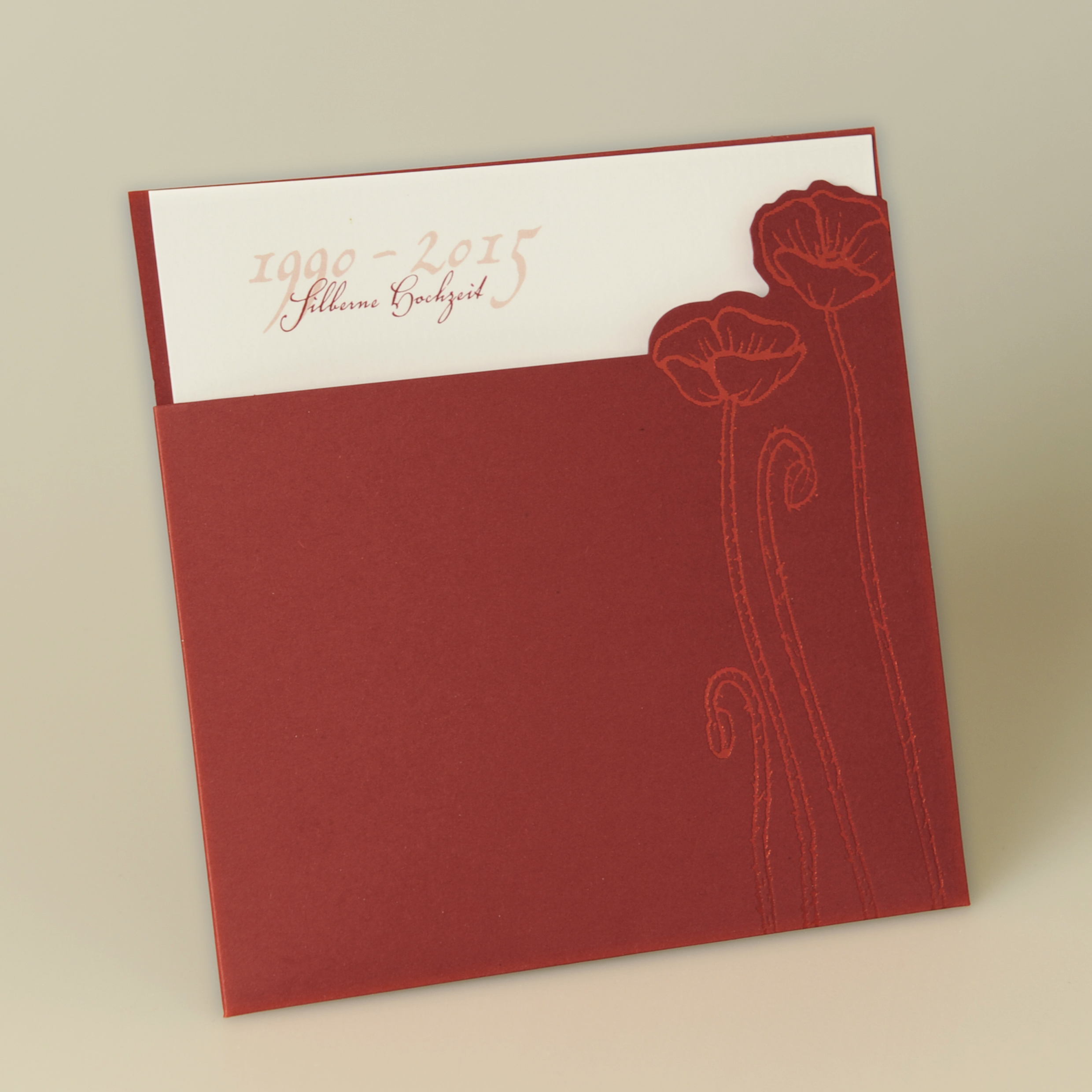 Weinrote quadratische Karte mit gedruckten Mohnblumen, weißem Einstecker und Kuvert weiß.